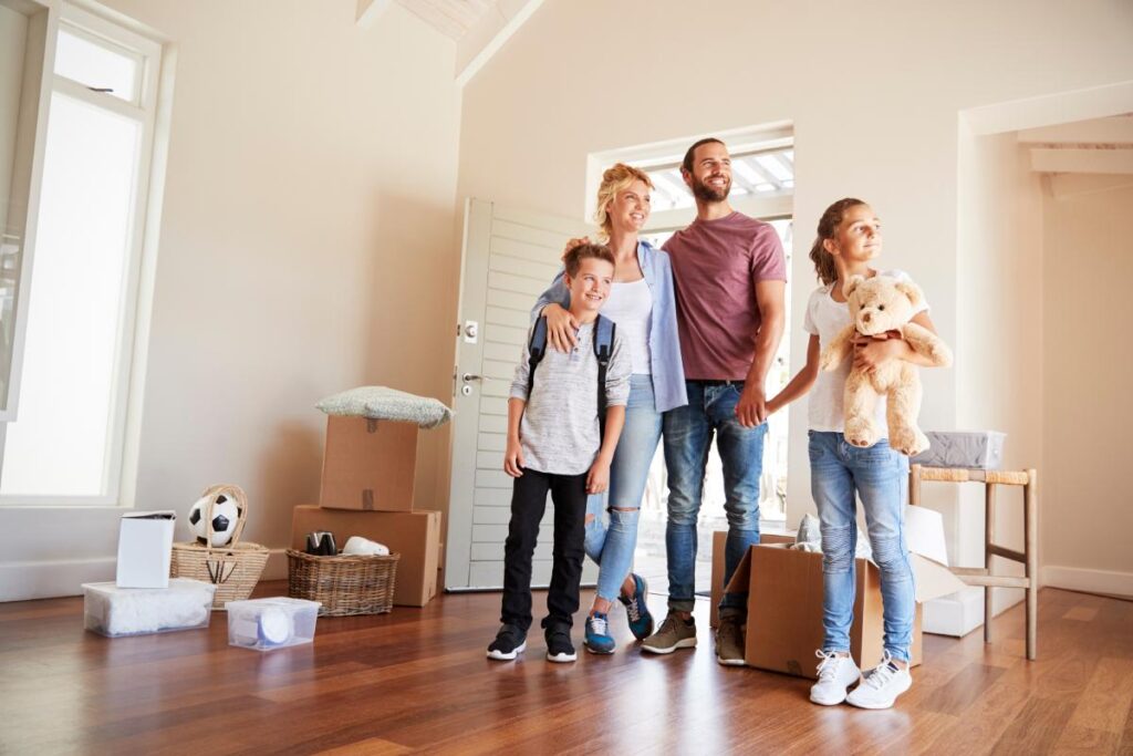 Excited Family In Lounge Of New Home On Moving Day